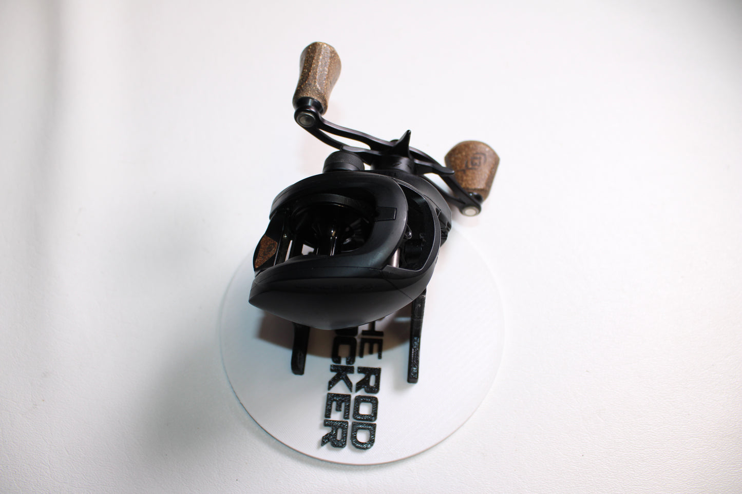 A 13 Fishing Concept A Gen II A2-6.8-LH Used Casting Reel in very good condition is displayed on a white circular stand labeled "THE ROD RACKER" against a plain white background.