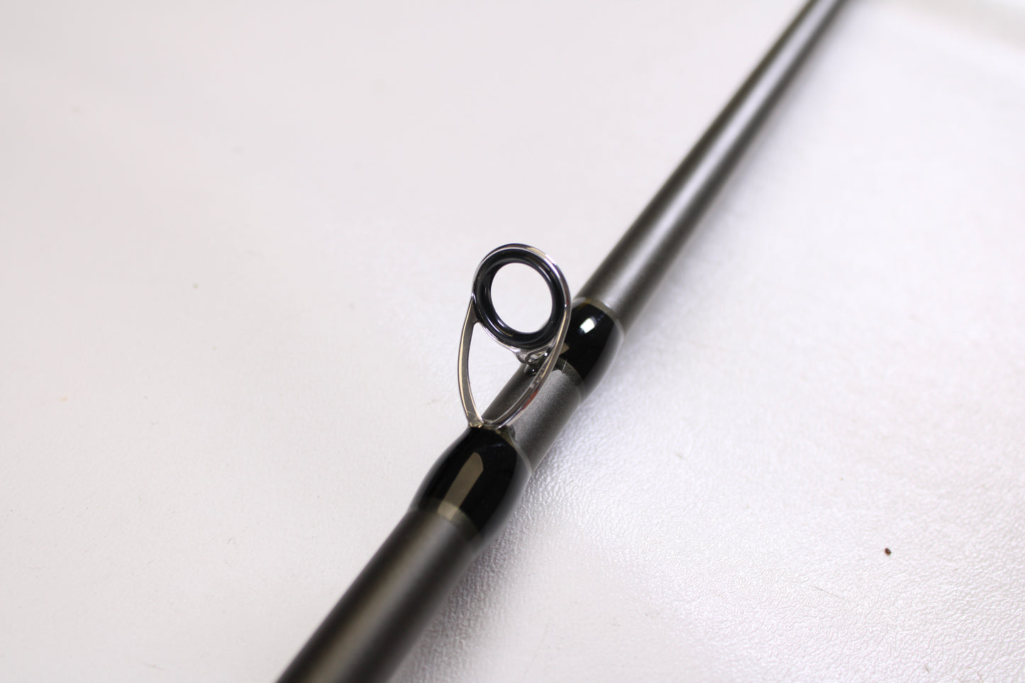 Close-up of a Douglas XMatrix DXC 807F 8'0" Extra Heavy Used Casting Rod in excellent condition, showing a single metal guide loop on the shaft—ideal for upgrading through our rod and reel trade-in program. Smooth, light background.