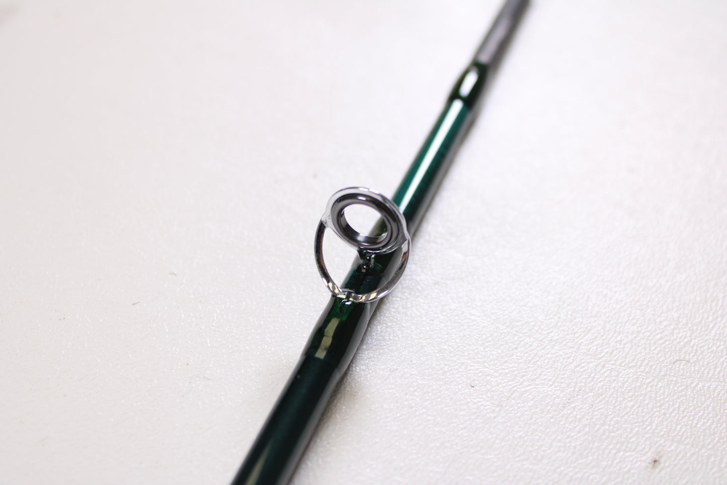 A close-up of the Orvis Frequent Flyer 908 9'0" 8 7pc Used Fly Rod in excellent condition by Sage, highlighting a metal line guide—ideal for those exploring our Rod and Reel Trade-In Program for store credit.