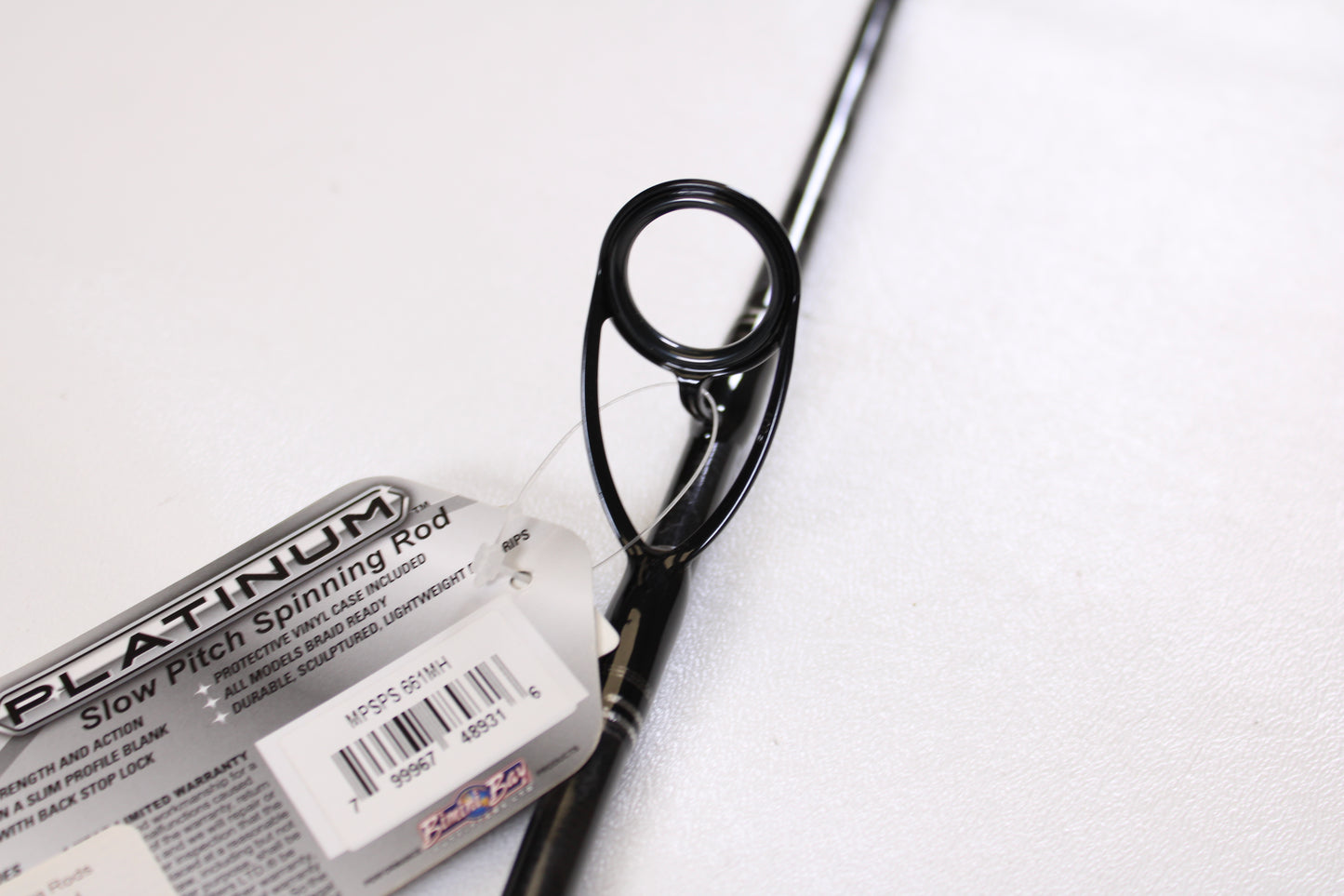 Close-up of a Maxel Platinum Slow Pitch MPSPS 661MH 6'6" Medium Heavy used spinning rod in mint condition, shown near the guide ring on a white surface—great for those interested in store credit or our rod and reel trade-in program.