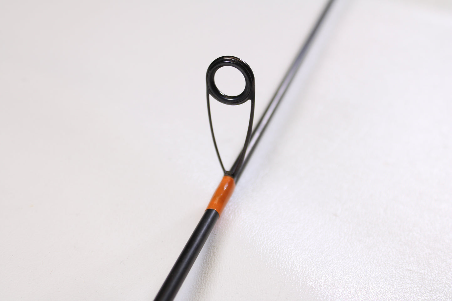 Close-up of a G. Loomis GCX Lite 6600S 5'6" Ultra Light used spinning rod in excellent condition, detailing the circular guide and orange threading—ideal for gear enthusiasts or rod and reel trade-ins; plain white background.