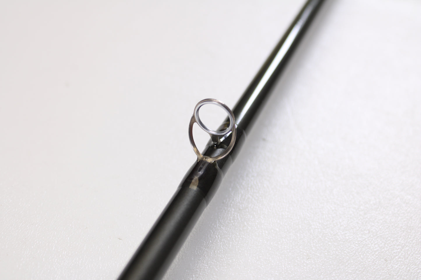 A close-up of the Temple Fork TFO Tactical Elite Bass TLE SC 747-1 7'4" Ex-Heavy Used Casting Rod in excellent condition, featuring a metal guide ring, photographed on a plain white surface.