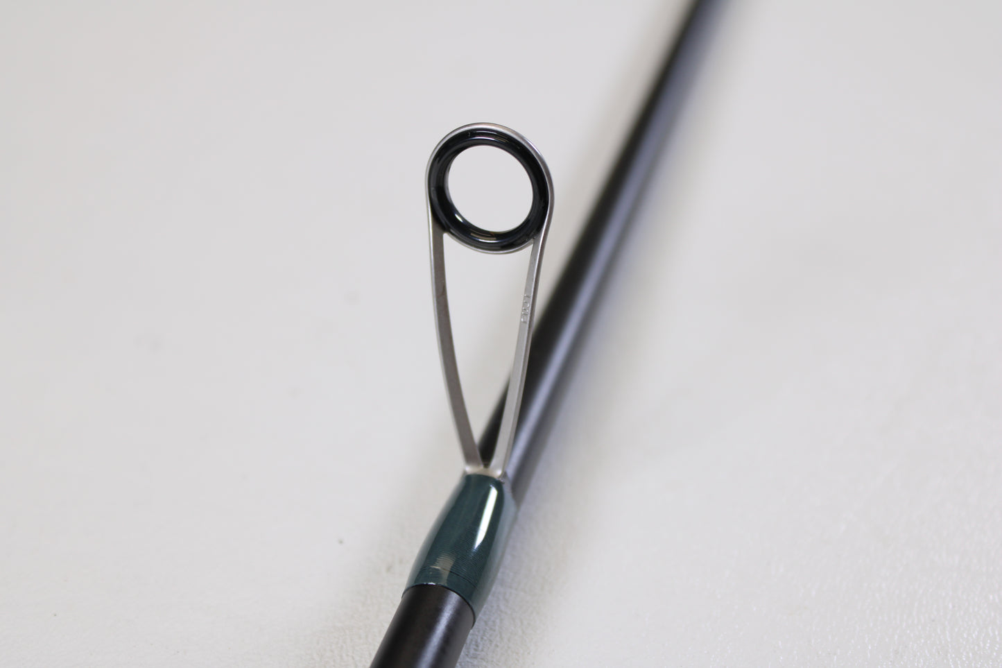 Close-up of the Vocelka Tournament Series The Spinn' Rod 7'1" Medium Light guide, showing its ring and support on a plain background. Ideal for those interested in trading or earning store credit with used Vocelka gear.