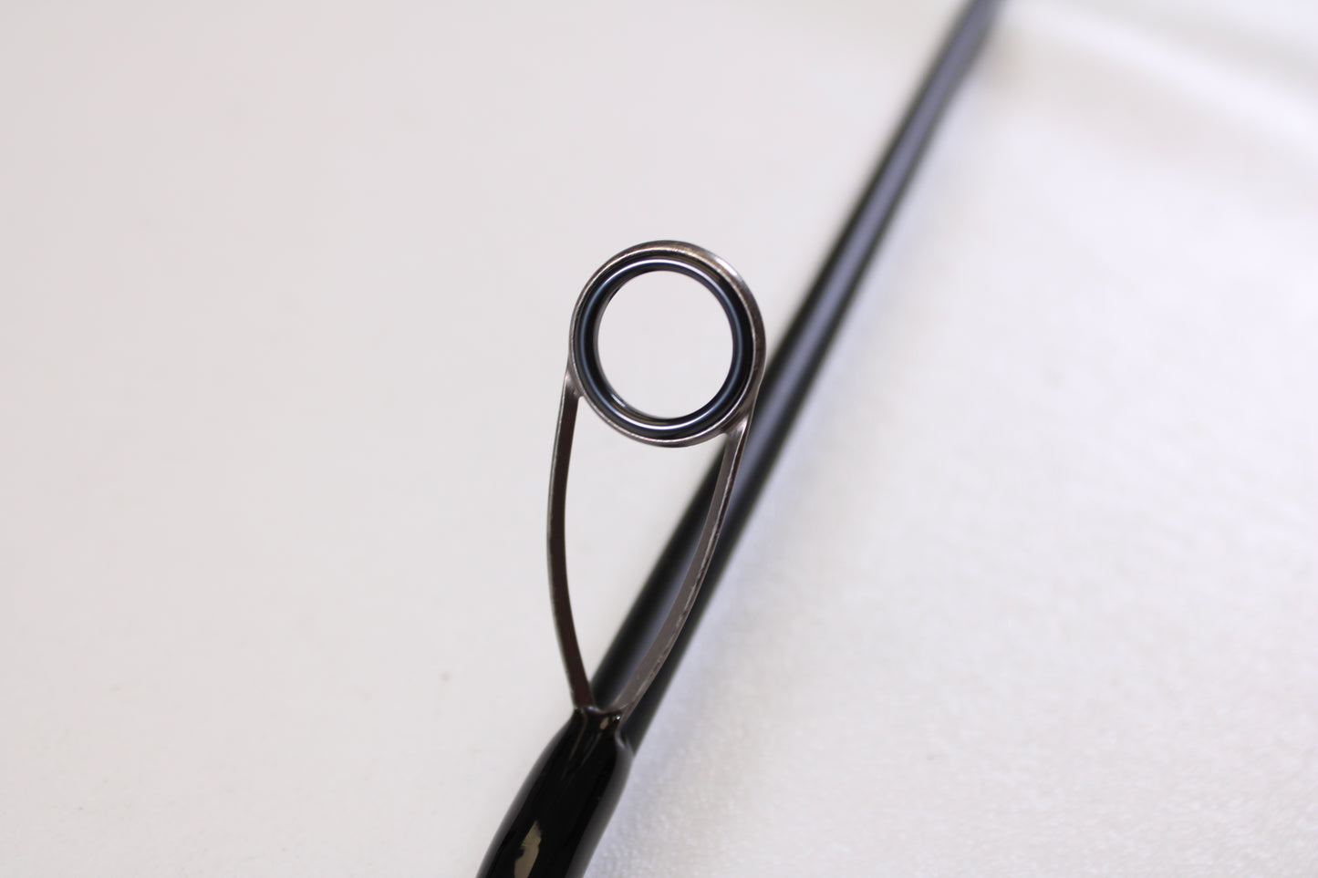Close-up of the Airrus Stargate ASG681LF-S 6'8" Light Used Spinning Rod’s tip and metal guide ring against a white background—ideal for those looking to trade in or upgrade fishing gear for store credit.