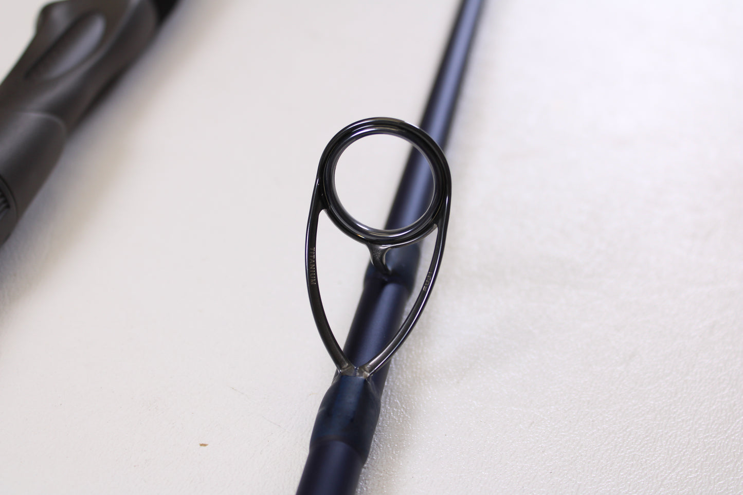 Close-up of the circular metal guide ring on a Tsunami SaltX Surf TSSTXIISS872M 8'7" Medium 2-Piece Spinning Rod (Used, Excellent Condition) by Tsunami—ideal for upgrade through our Rod and Reel Trade-In Program.