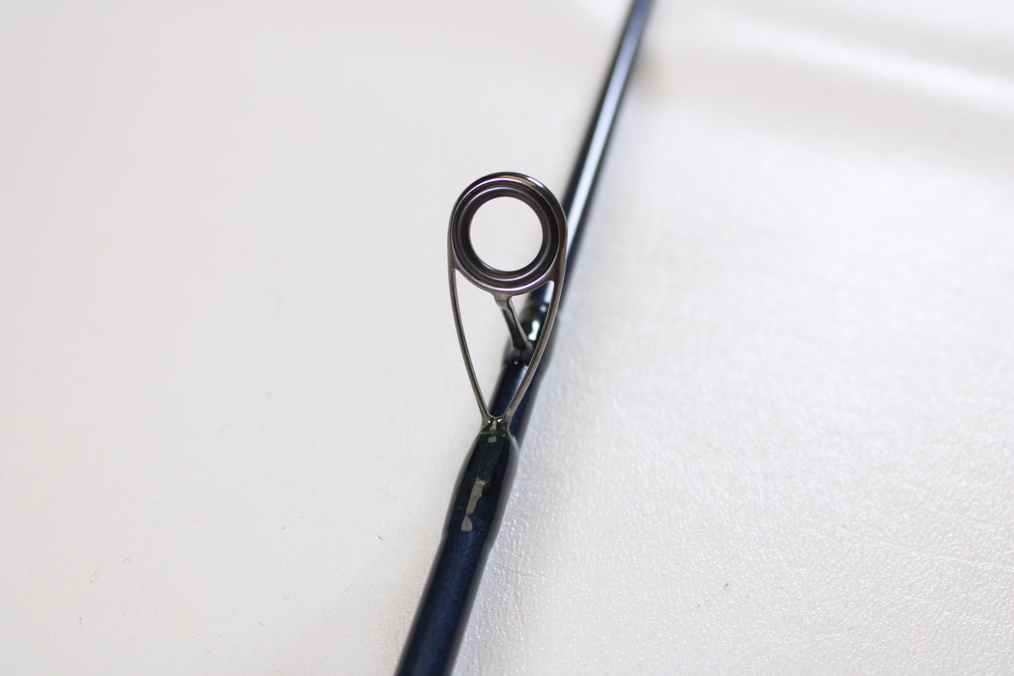 Close-up of a St. Croix Seage SES70MMF 7'0" Medium Used Spinning Rod in mint condition, highlighting the guide ring with its metal eyelet and supports—ideal for upgrading gear through our Trade-In Program. Shown on a plain white background.