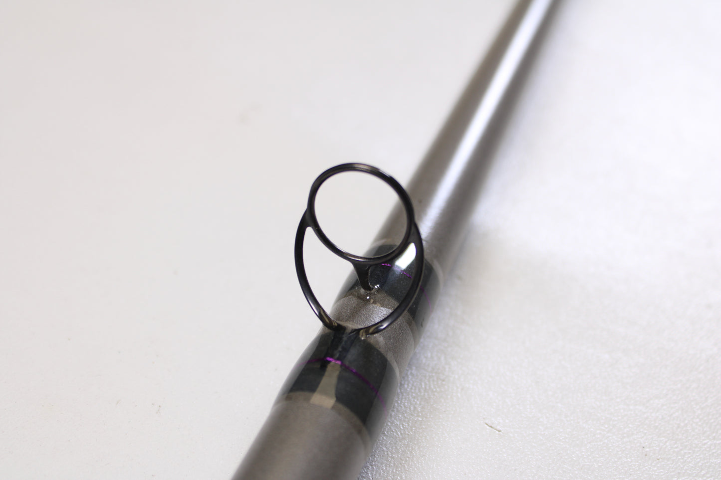 Close-up of the St. Croix Mojo Musky Trolling MMT90XHM2 9'0" XH used casting rod’s guide ring and support—ideal for anglers trading in gear for store credit with our Rod and Reel Trade-In Program. Mint condition. Set against a white background.