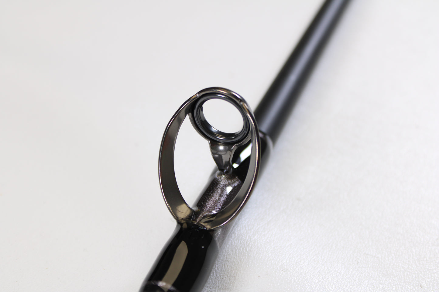 Close-up of the guide on a G. Loomis IMX-PRO Offshore 96-40 8'0" Medium Heavy Used Casting Rod in mint condition—ideal for anyone using our rod and reel trade-in program for store credit on used gear.