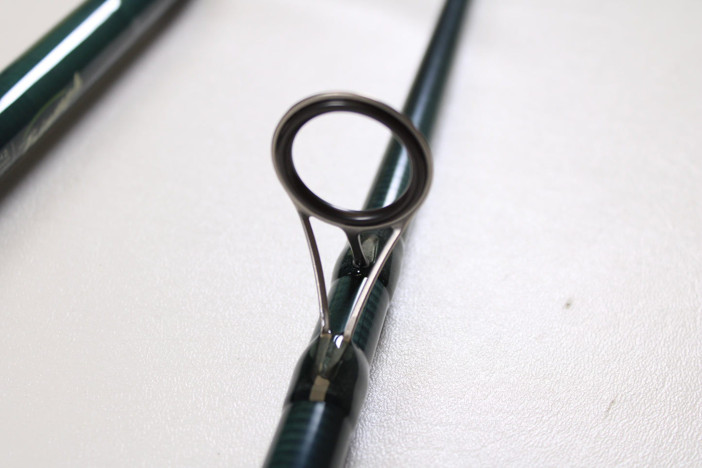 Close-up of the St. Croix Triumph Surf TSF106MH2 10'0" Medium Heavy 2 Piece used spinning rod in mint condition, highlighting its sturdy metal guide—ideal for anglers upgrading gear or using our Rod and Reel Trade-In Program.