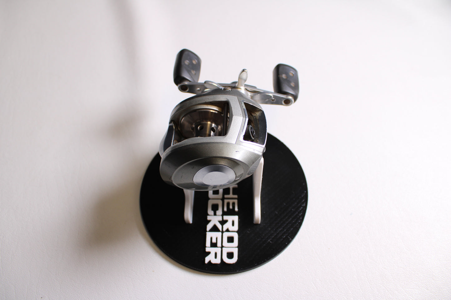 A used Abu Garcia Revo S-L Left Hand casting reel in fair condition by Abu Garcia is displayed on a white surface.
