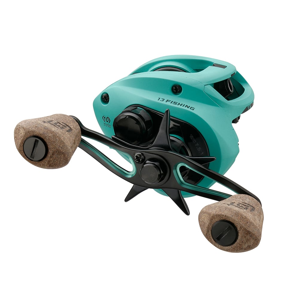 The 13 Fishing Concept TX2 Casting Reel 6.8:1 (TX2-6.8-RH) features a teal low-profile design, two tan cork handles, black star drag control, and visible 13 Fishing branding on the side.