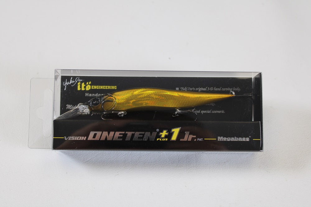 The Megabass Vision 110+1 Jr. Jerkbait (SP-C) in Alien Gold is shown in clear packaging with black and yellow Megabass branding, offering a premium suspending lure ideal for attracting trophy fish.