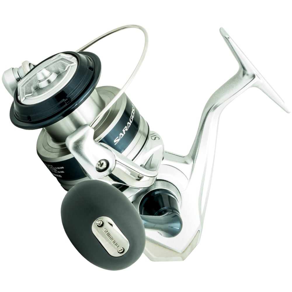 The Shimano Saragosa Spinning Reel 6000SWAHG 5.7:1 by Shimano features a silver and black design, large handle, "Saragosa" branding, visible spool, bail arm, and advanced Infinity Drive Technology for powerful saltwater fishing.