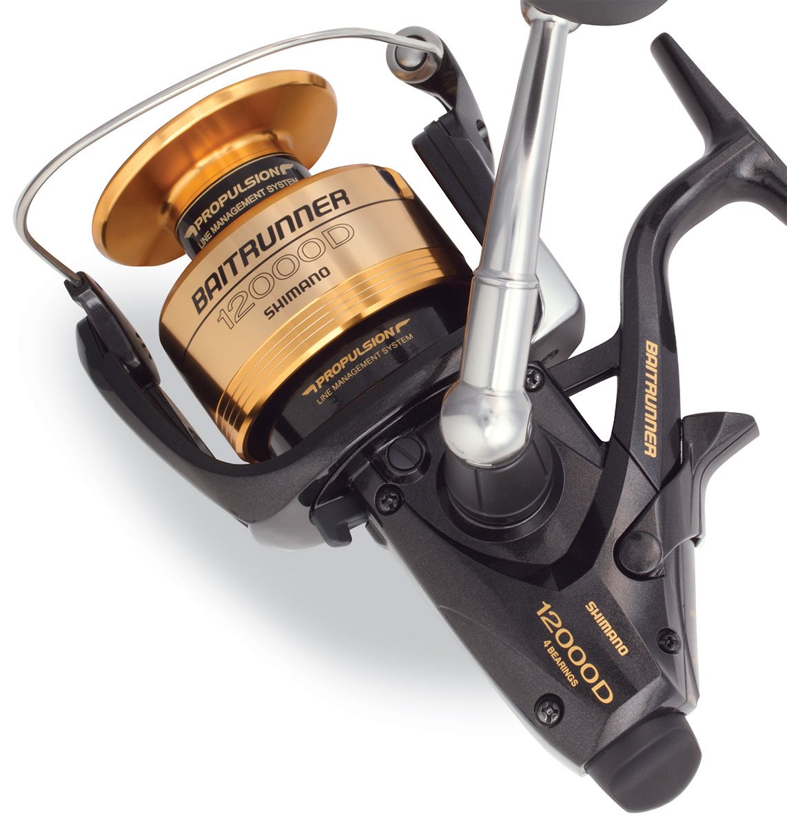 A close-up of the Shimano Baitrunner BTR12000D Spinning Fishing Reel shows its gold and black spool, branded handle, and Propulsion Line Management System, all displayed on a white background.