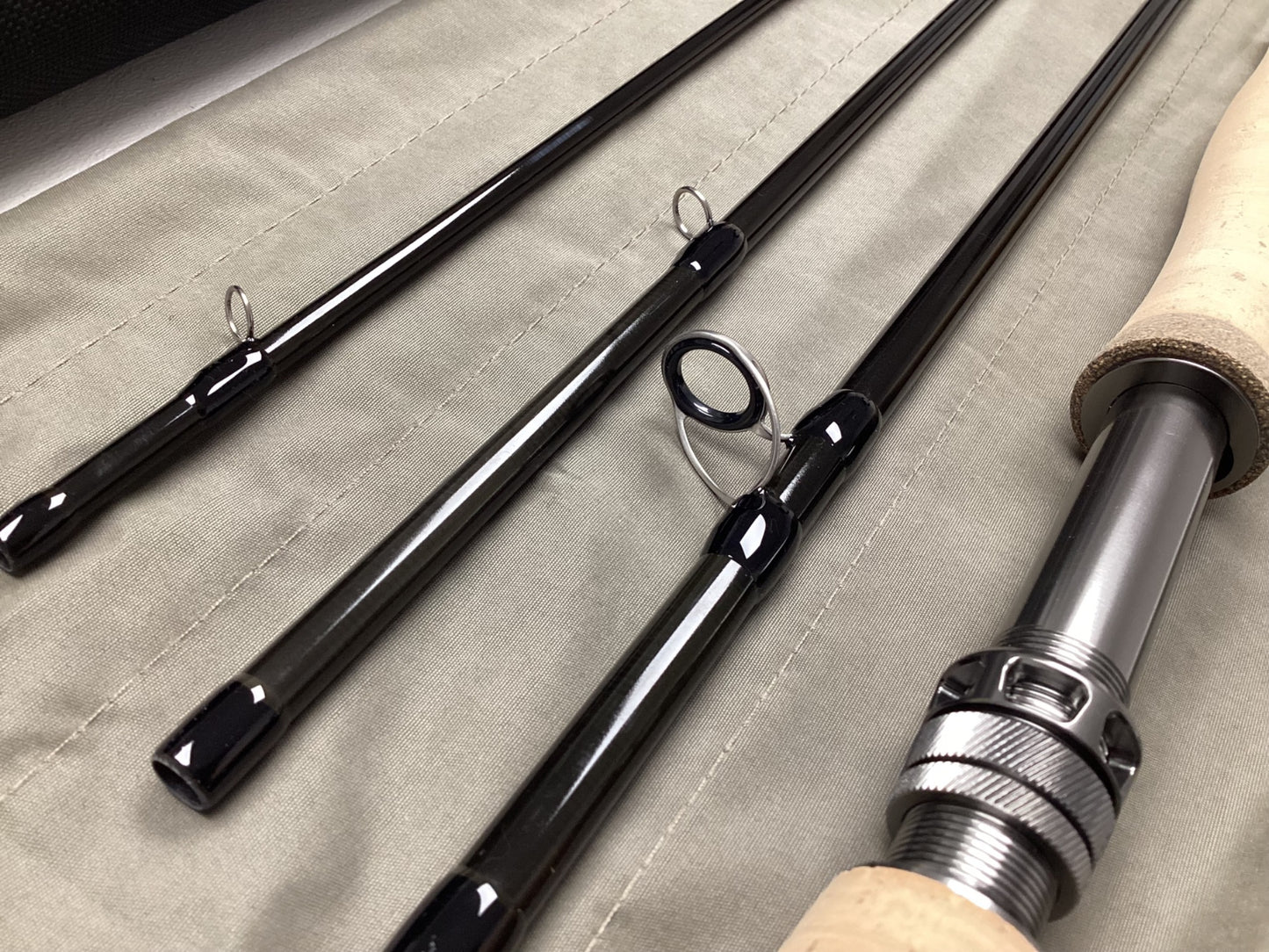 The G. Loomis IMX-PRO V2 Fly Rod 8100-4 10'0" #8, in mint used condition, features four sections with guides and a cork handle with metal reel seat—ideal for anglers or those interested in our rod and reel trade-in program.