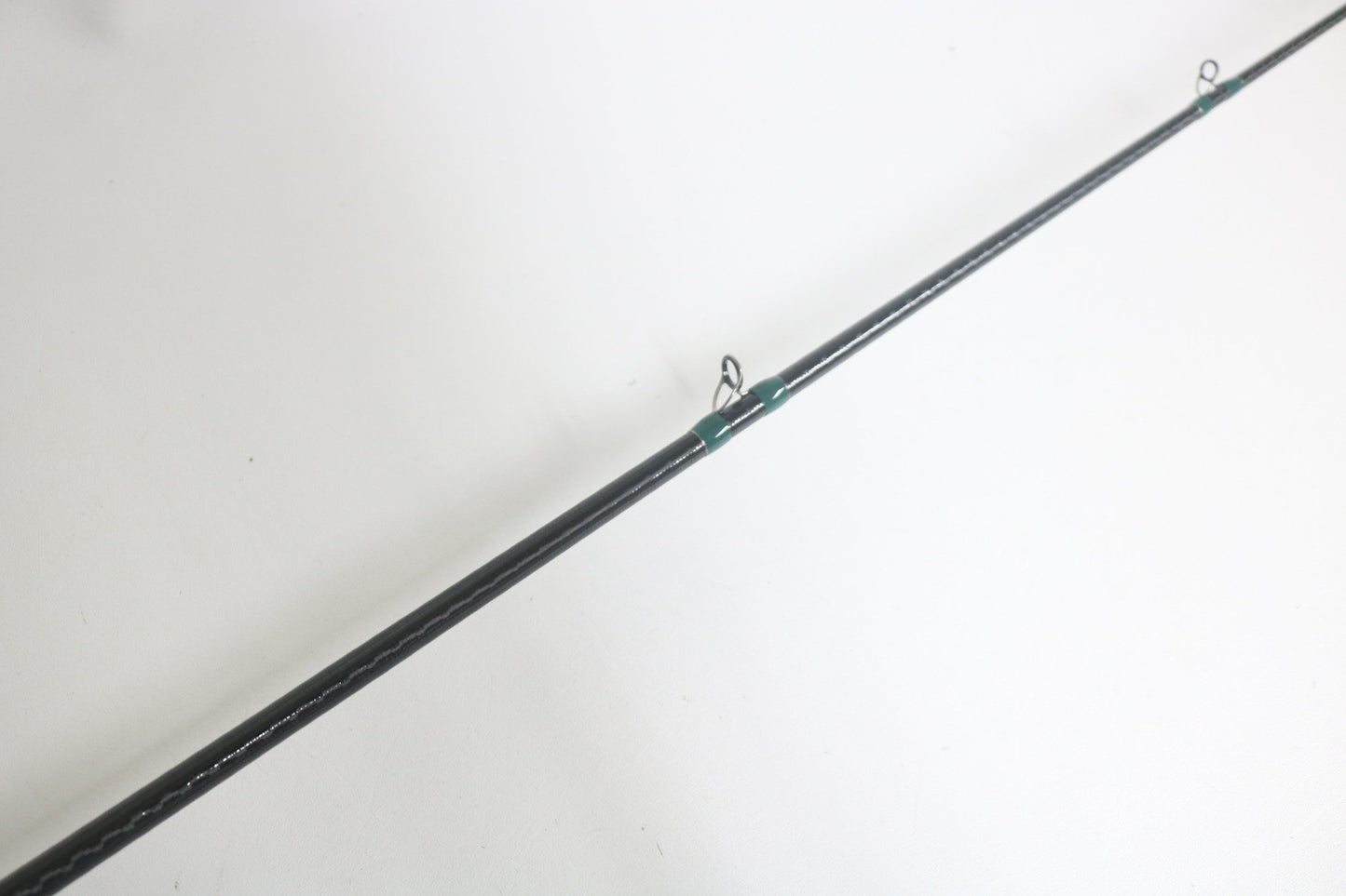 A close-up of the G. Loomis Conquest CNQ 903C MBR 7'6" Medium Heavy Used Casting Rod in good condition, shown diagonally on a white background—perfect for upgrading your gear with our trade-in program for store credit.