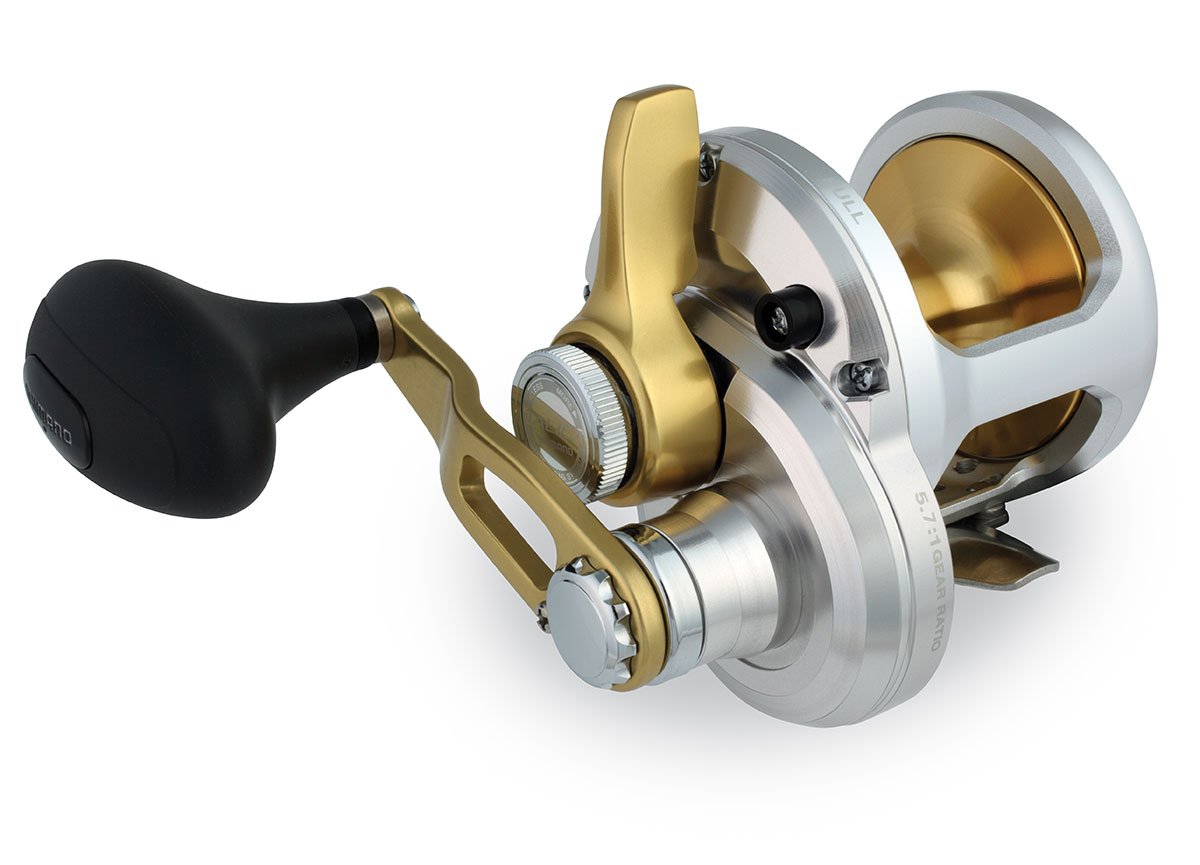 A close-up of the Shimano Talica TAC12 Lever Drag Reel by Shimano, featuring a sleek silver and gold finish, black ergonomic handle, modern metallic design, and smooth drag system.