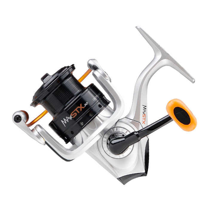 A silver and black fishing reel with orange accents, featuring a spinning mechanism and a handle on the right side, set against a white background.