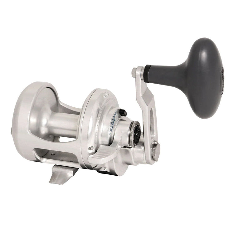 Silver fishing reel with a black handle. The reel has a smooth, rounded design and a visible spool. It's positioned at an angle, highlighting its curvy structure and ergonomic handle.