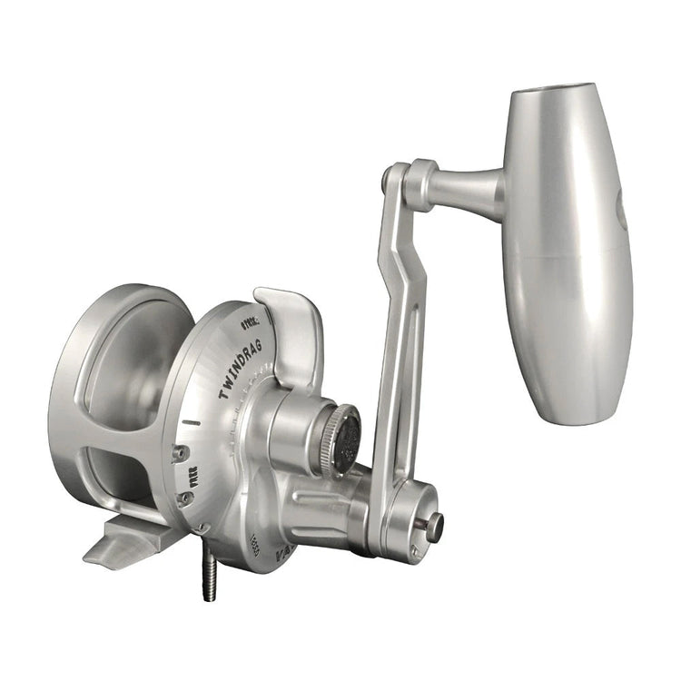 A silver fishing reel with a large handle, featuring the word "TWINDRAG" engraved on its side, is positioned against a plain white background.