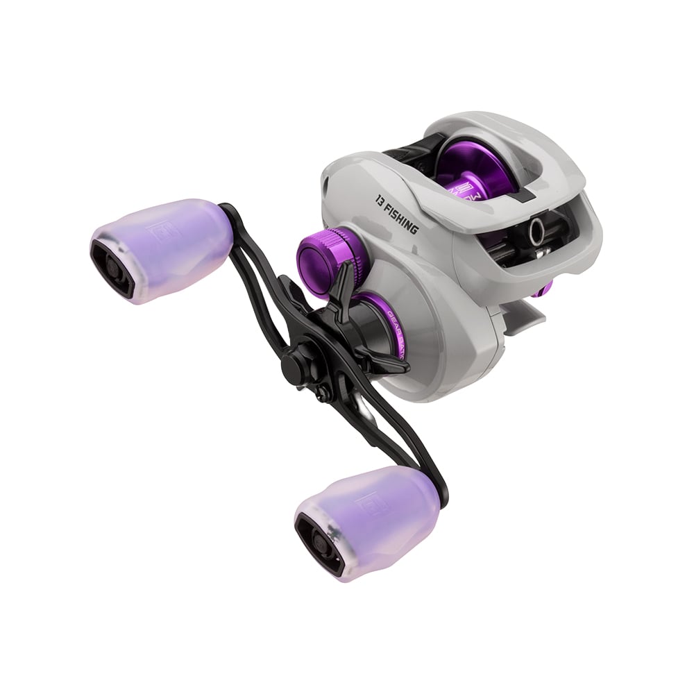 The 13 Fishing Modus SZ2 Casting Reel 7.3:1 RH features a white and purple body with black and purple crank handles, metallic accents, Japanese Hamai Cut Gearing, and a modern ergonomic design, displayed on a plain white background.