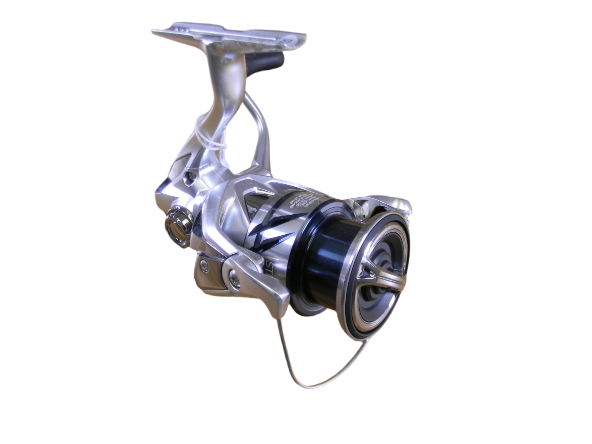 A close-up of the Shimano Stradic ST2500HGFM spinning reel showcases its silver and black design, intricate mechanics, and spool against a plain white background. Eligible for our Rod and Reel Trade-In program to upgrade your adventure with store credit from used gear!.
