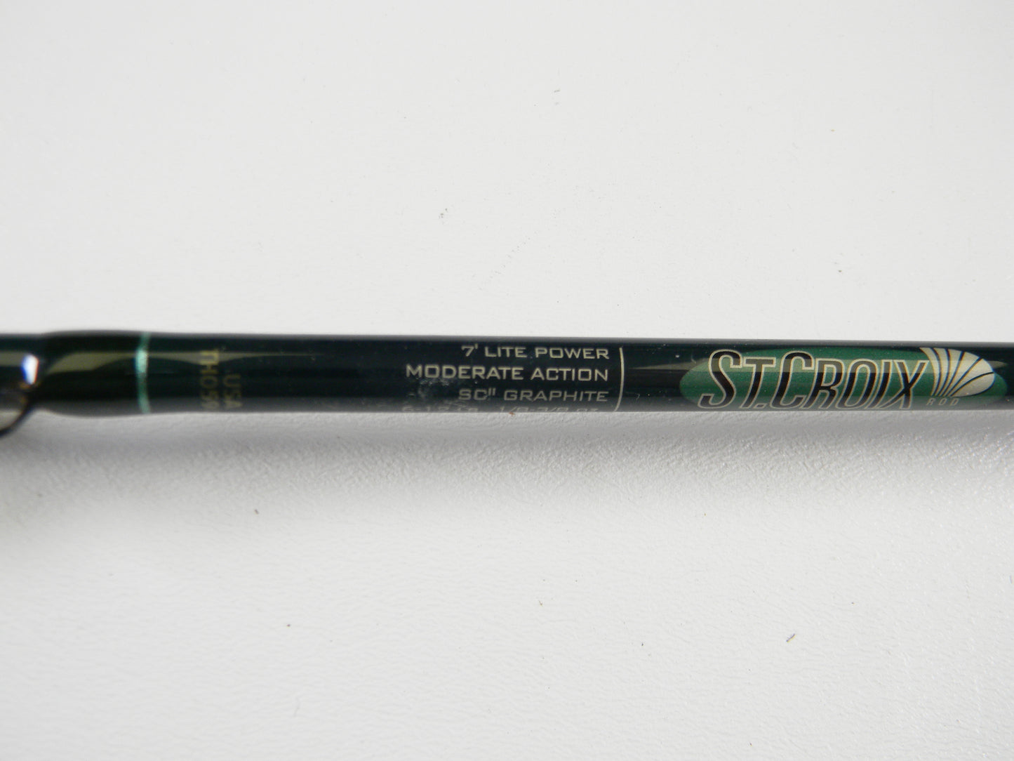 A close-up of a St. Croix Tidemaster TIC70LM 7'0" Light Used Casting Rod in excellent condition, suitable for the Rod and Reel Trade-In Program, with "ST. CROIX" and product details visible on the rod.