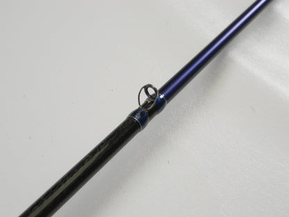 The Okuma TCS TCS-C-701MH 7'0" Medium Heavy Used Casting Rod, in excellent condition, features a close-up of its metal guide ring on a white surface. Trade it in via our Rod and Reel Program to earn store credit or explore quality used gear.