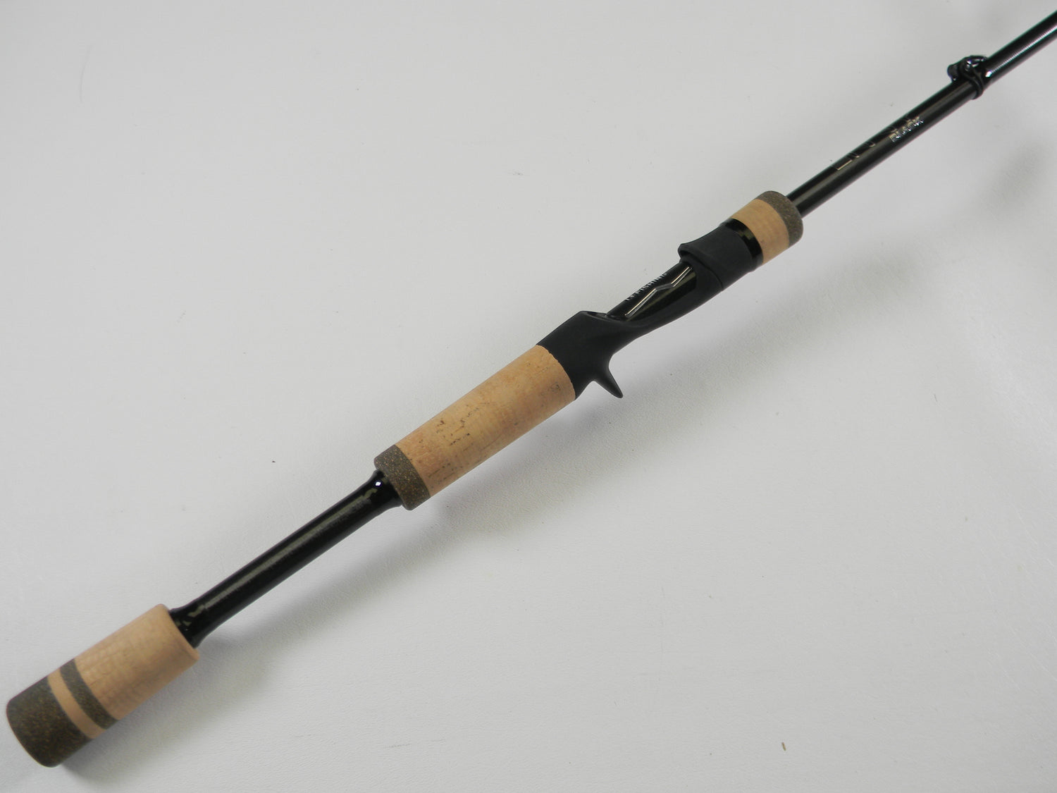 A close-up of the 13 Fishing Envy Black 3 EB3C71M 7'1" Medium Used Casting Rod in excellent condition, with black hardware and cork handles—ideal for anglers exploring trade-in or used gear options.