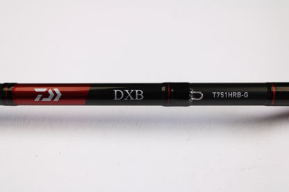 Close-up of a Daiwa DXB DXBT751HRB-G 7'5" Heavy Glass Used Casting Rod in excellent condition, black and red with branding visible, on a white background. Ideal for anglers upgrading via our rod and reel trade-in program for store credit.