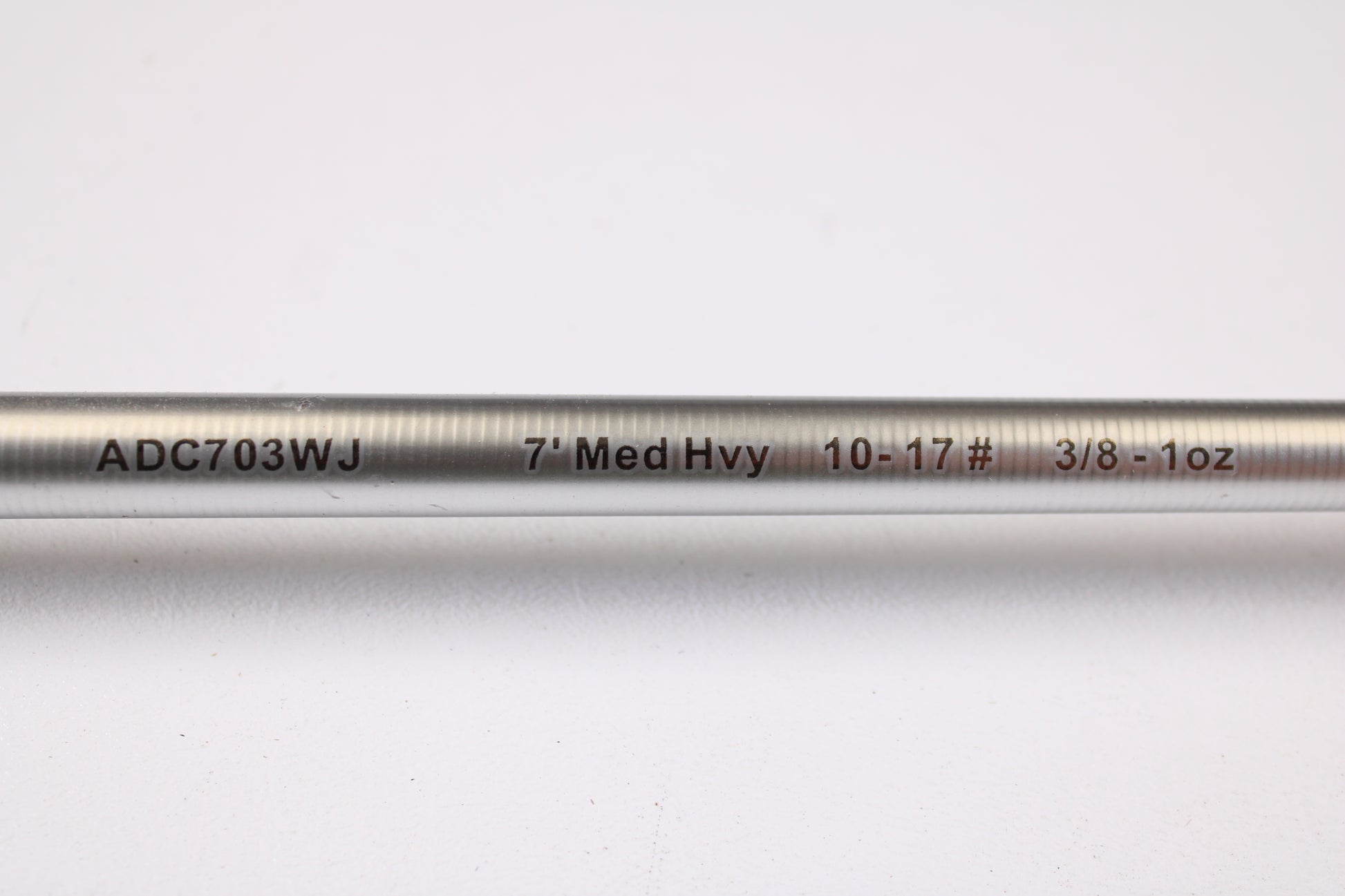 A close-up of the Denali Android ADC703WJ 7'0" Medium Heavy Used Casting Rod in good condition, showing black and red labeling on a silver surface, featured in our used gear trade-in program against a white background.