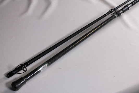 Two sections of the Shimano Speedmaster Surf SPMS120H2 12'0" Heavy 2 Piece - Used Spinning Rod (Mint Condition) by Shimano are displayed parallel on a white surface, clearly showing their guides and tips—ideal for gear enthusiasts.