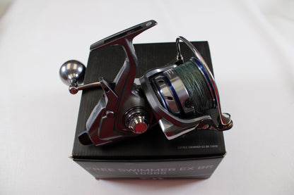 A Daiwa Free Swimmer EX BR 10000 used spinning reel in excellent condition, with a green fishing line spool, is mounted on a black box labeled "FREE SWIMMER EX BR 10000" against a plain white background—ideal for trade-in.