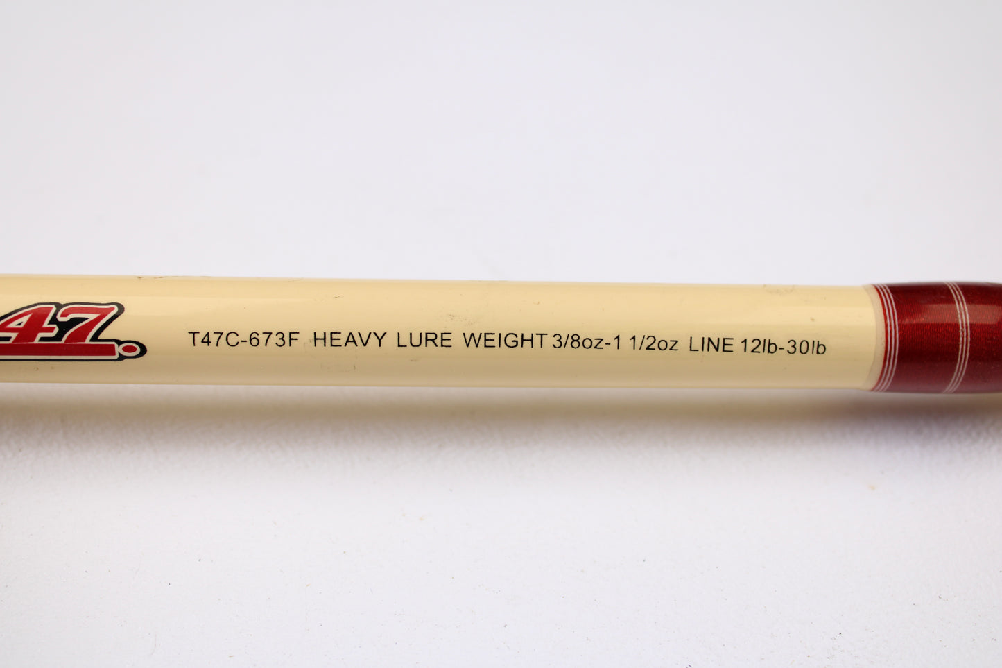A close-up of the Doomsday Tackle Co. The 47 T47C-673F 7'3" Heavy Used Casting Rod (Very Good), specs: "HEAVY 3/8oz-1 1/2oz LURE, 12lb-30lb LINE," ideal for rod and reel trade-in, on a cream background with red accent.