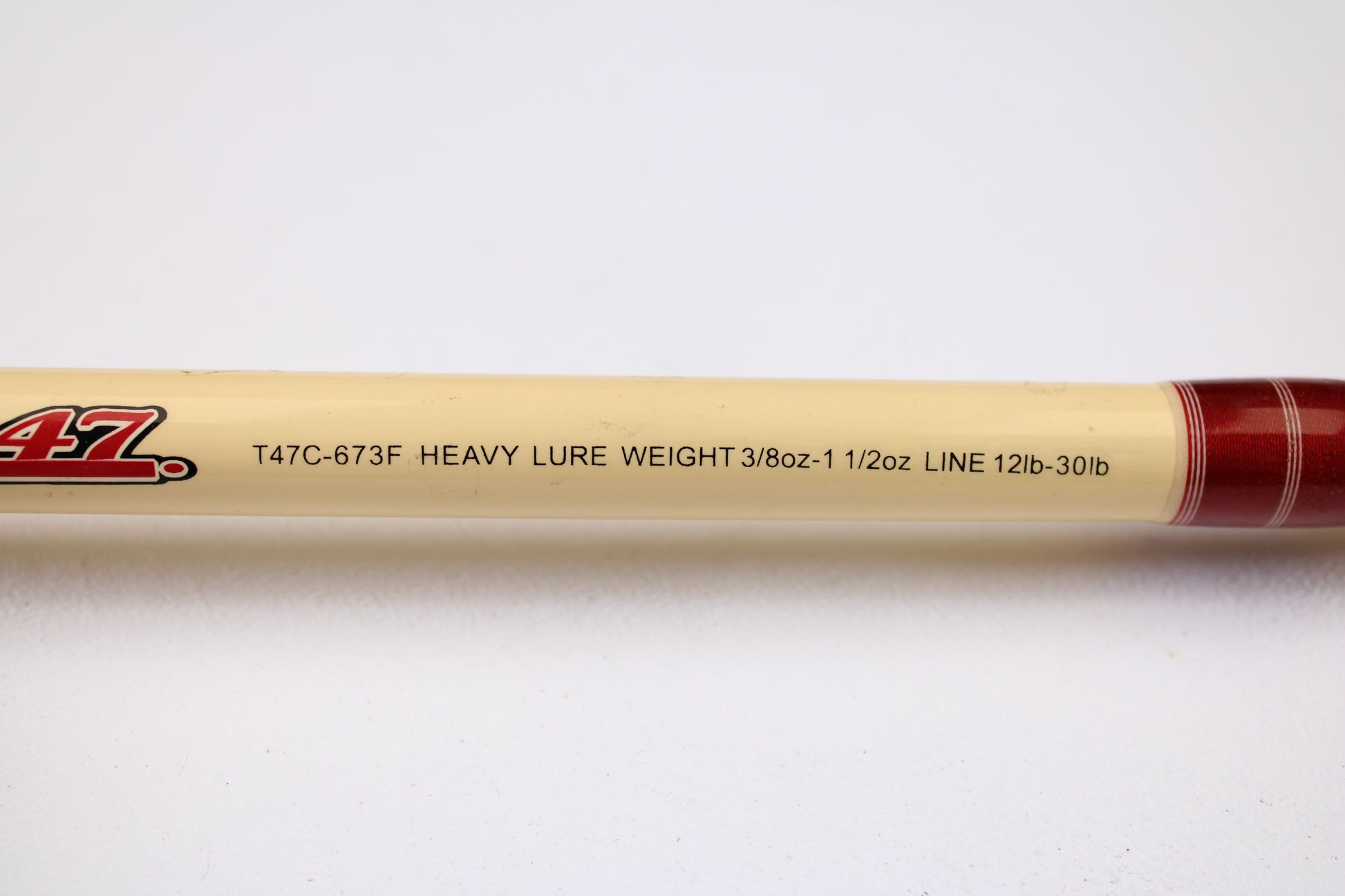 A close-up of the Doomsday Tackle Co. The 47 T47C-673F 7'3" Heavy Used Casting Rod (Very Good), specs: "HEAVY 3/8oz-1 1/2oz LURE, 12lb-30lb LINE," ideal for rod and reel trade-in, on a cream background with red accent.