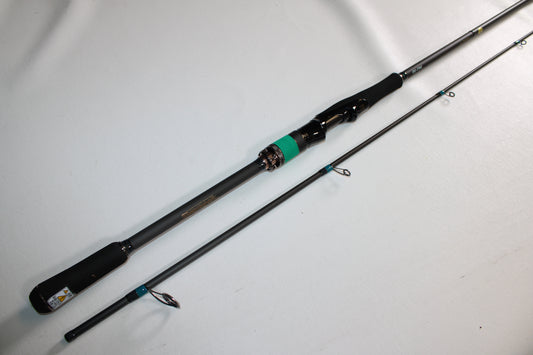 The Megabass Cookai Gulf CKG77MS is a 2-piece spinning rod with a black handle and metallic reel seat, shown disassembled on a white background. This used Megabass rod is in excellent condition.