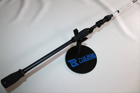 A 6th Sense Divine RODDIV-M73S Used Spinning Rod in excellent condition is displayed on a black circular stand labeled "THE ROD LOCKER" with a blue logo, set against a plain white background.