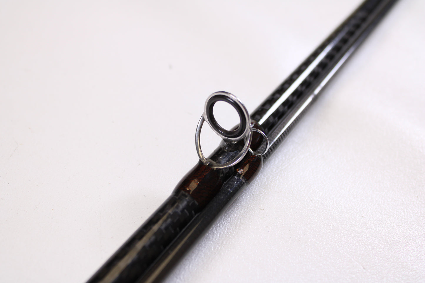 Close-up of an American Tackle Matrix 10'6" 10WT 2 Piece Used Fly Rod in excellent condition—black carbon-fiber shaft and metal guide shown. Trade in your used gear for store credit through our Rod and Reel Trade-In Program!.