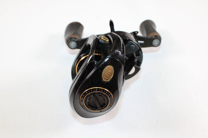 A Lew's Lite MgF LFS 7.5:1 LH Used Casting Reel in good condition—with black finish, gold accents, and wooden handle grips—is shown on a white background, ideal for Rod and Reel Trade-In or assessing Used Gear Condition.
