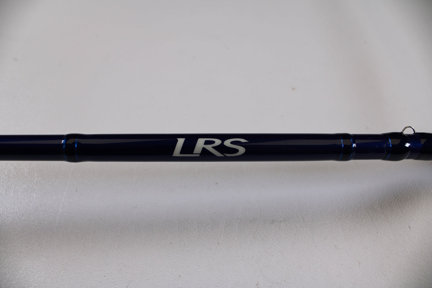 A close-up of the Douglas LRS C704M 7'0" Medium Used Casting Rod in excellent condition, featuring "LRS" in white on a dark blue surface—ideal for those interested in our Rod and Reel Trade-In Program.
