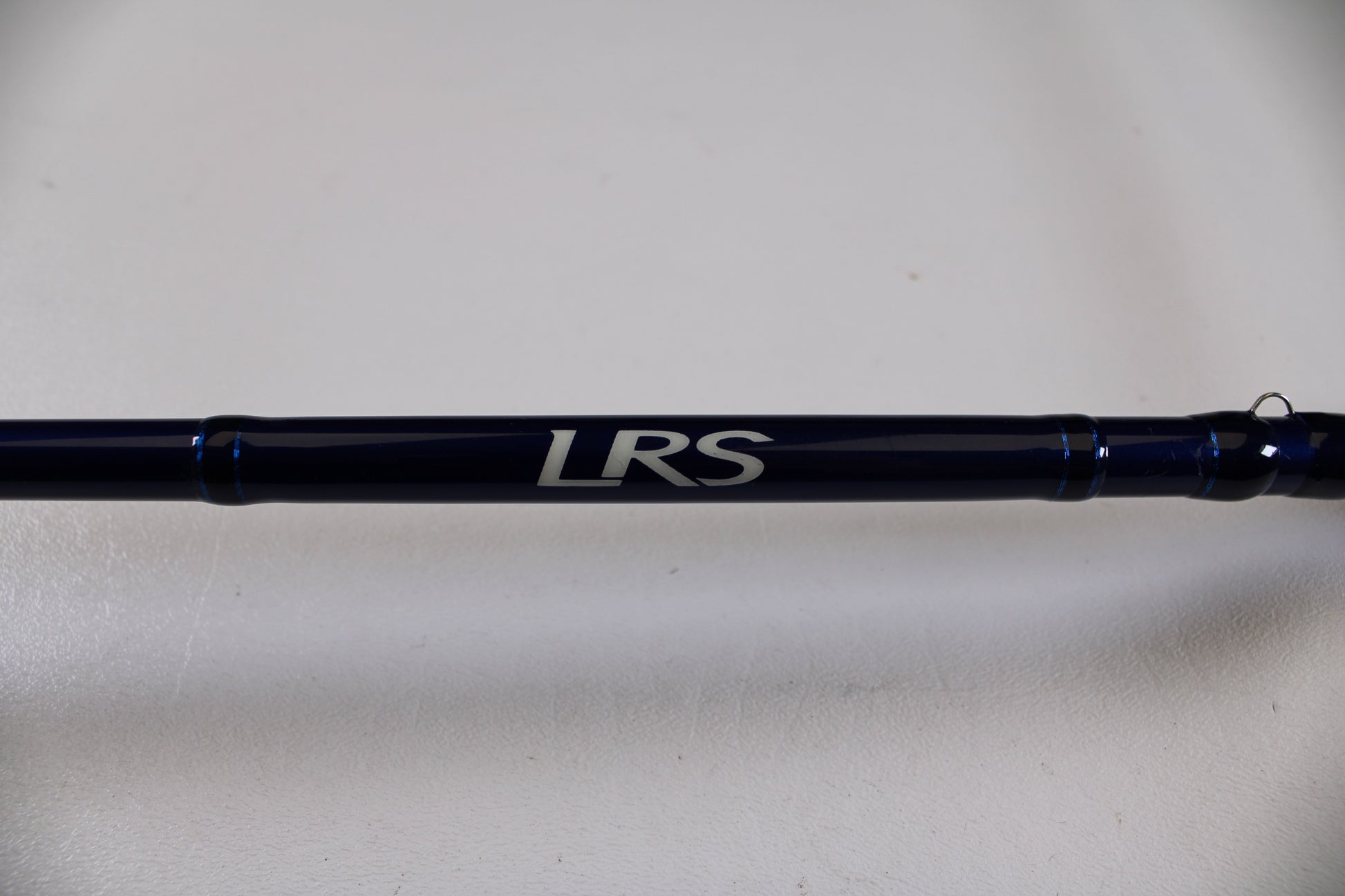 A close-up of the Douglas LRS C704M 7'0" Medium Used Casting Rod in excellent condition, featuring "LRS" in white on a dark blue surface—ideal for those interested in our Rod and Reel Trade-In Program.