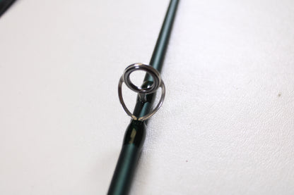 Close-up of the Douglas DXF Gen 1 6964 9'6" 6wt 4pc Used Fly Rod in excellent condition, highlighting its metal guide on a green rod. Ideal for those exploring our rod and reel trade-in program.
