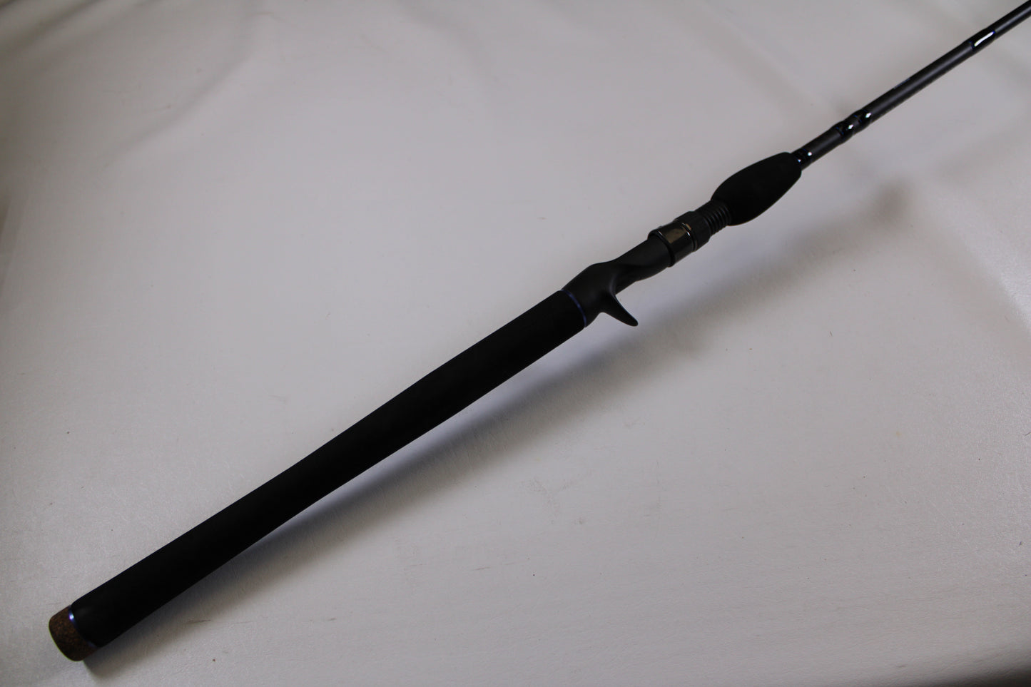 A close-up of the Dobyns Champion XP DC795SB Used Casting Rod in excellent condition with a textured handle, angled on a white background—ideal for upgrading your gear or taking advantage of our trade-in program.