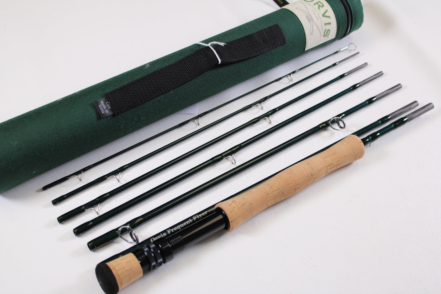 A disassembled Sage Orvis Frequent Flyer 908 9'0" 8wt 7pc fly rod in excellent condition is displayed beside a green carrying case—ideal for upgrading with our Rod and Reel Trade-In Program and earning store credit on used gear.