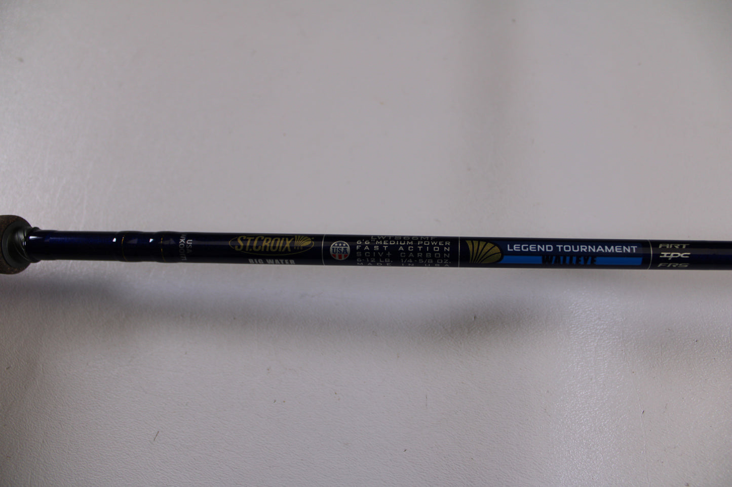 A close-up of a St. Croix Legend Tournament Walleye LWTS66MF Used Spinning Rod in excellent condition, part of our Rod and Reel Trade-In Program, shown on a plain white surface—eligible for store credit.