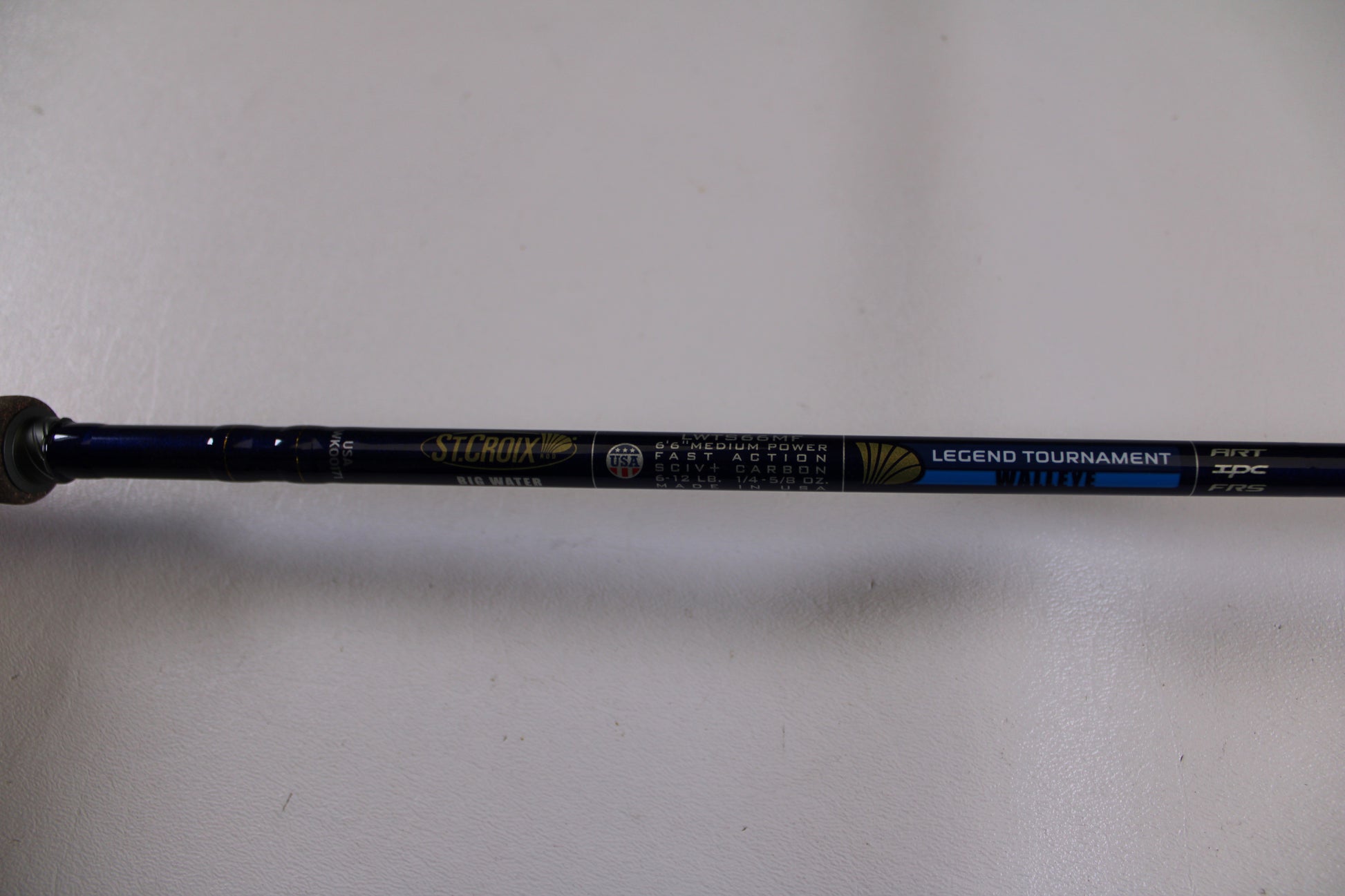 A close-up of a St. Croix Legend Tournament Walleye LWTS66MF Used Spinning Rod in excellent condition, part of our Rod and Reel Trade-In Program, shown on a plain white surface—eligible for store credit.