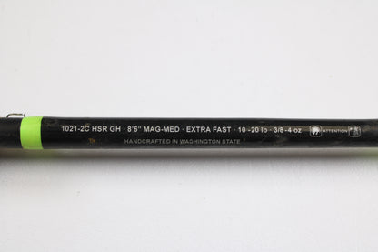 Close-up of a G. Loomis E6X Hot Shot 1021-2C HSR GH 8'6" Mag Medium 2pc used casting rod in good condition, featuring white specs and "HANDCRAFTED IN WASHINGTON STATE"—ideal for trade-ins or buying with store credit.