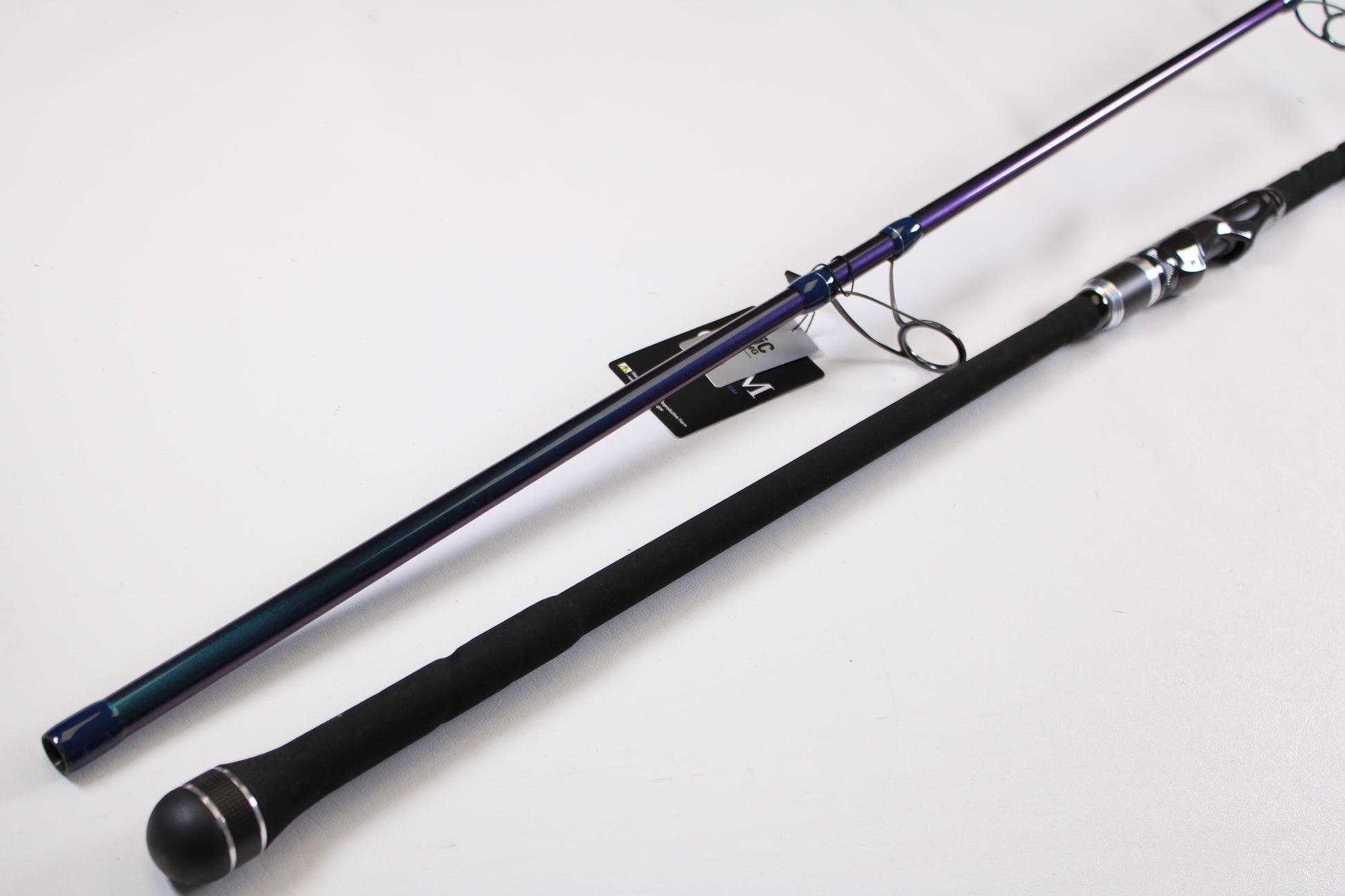 Two ODM Rods EVO X NXEX-116 11'0" used spinning rods in excellent condition, featuring black foam handles and metallic reel seats, are pictured diagonally on a white surface—great candidates for our Rod and Reel Trade-In Program.