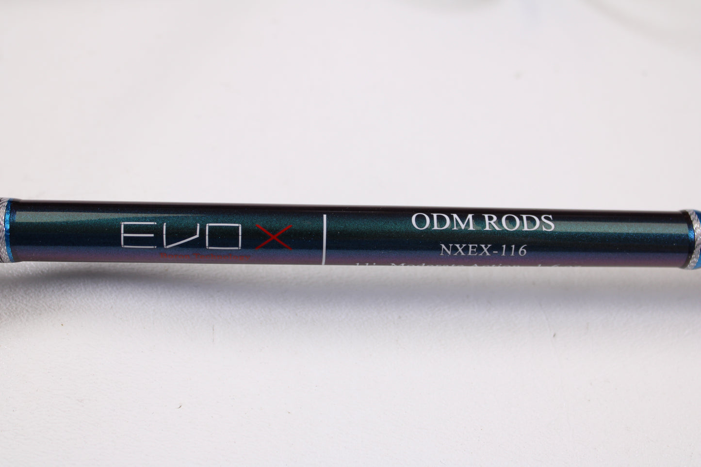 A close-up of the ODM Rods EVO X NXEX-116 11'0" 2pc Used Spinning Rod in excellent condition on a light surface, perfect for those interested in quality used gear or the Rod and Reel Trade-In Program for store credit.