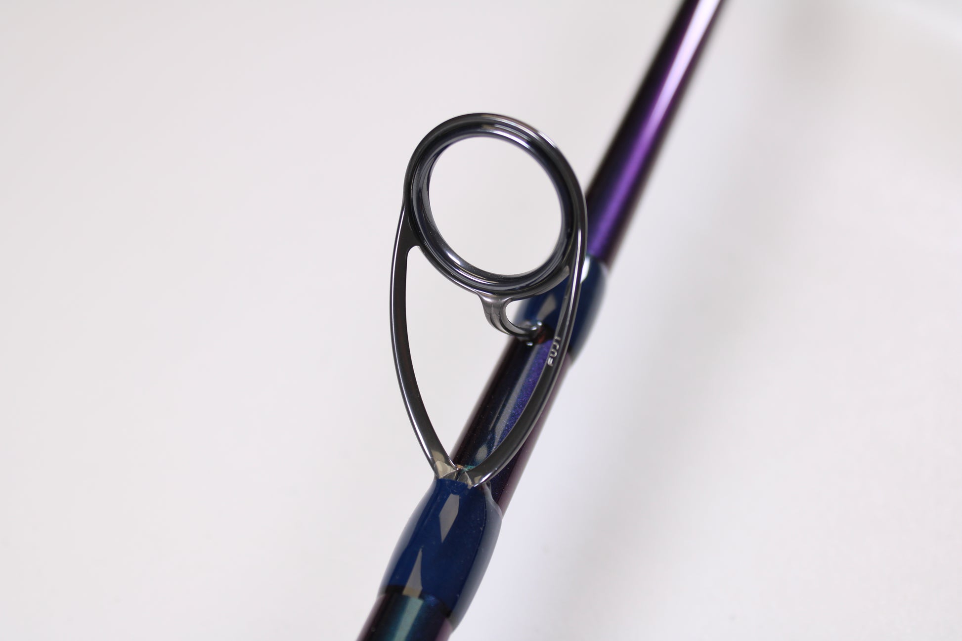 Close-up of an ODM Rods EVO X NXEX-116 11'0" 2pc Used Spinning Rod in excellent condition, featuring a guide ring on a purple and blue rod. Trade in your old gear for store credit with our Rod and Reel Trade-In Program. White background.